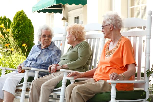 Senior living residents sitting on porch